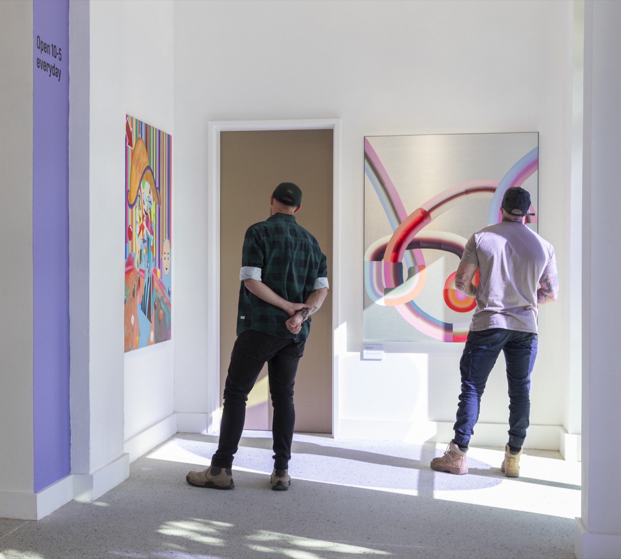 Visitors moving through the Waverley Art Prize beside gallery graphics and artwork labels.